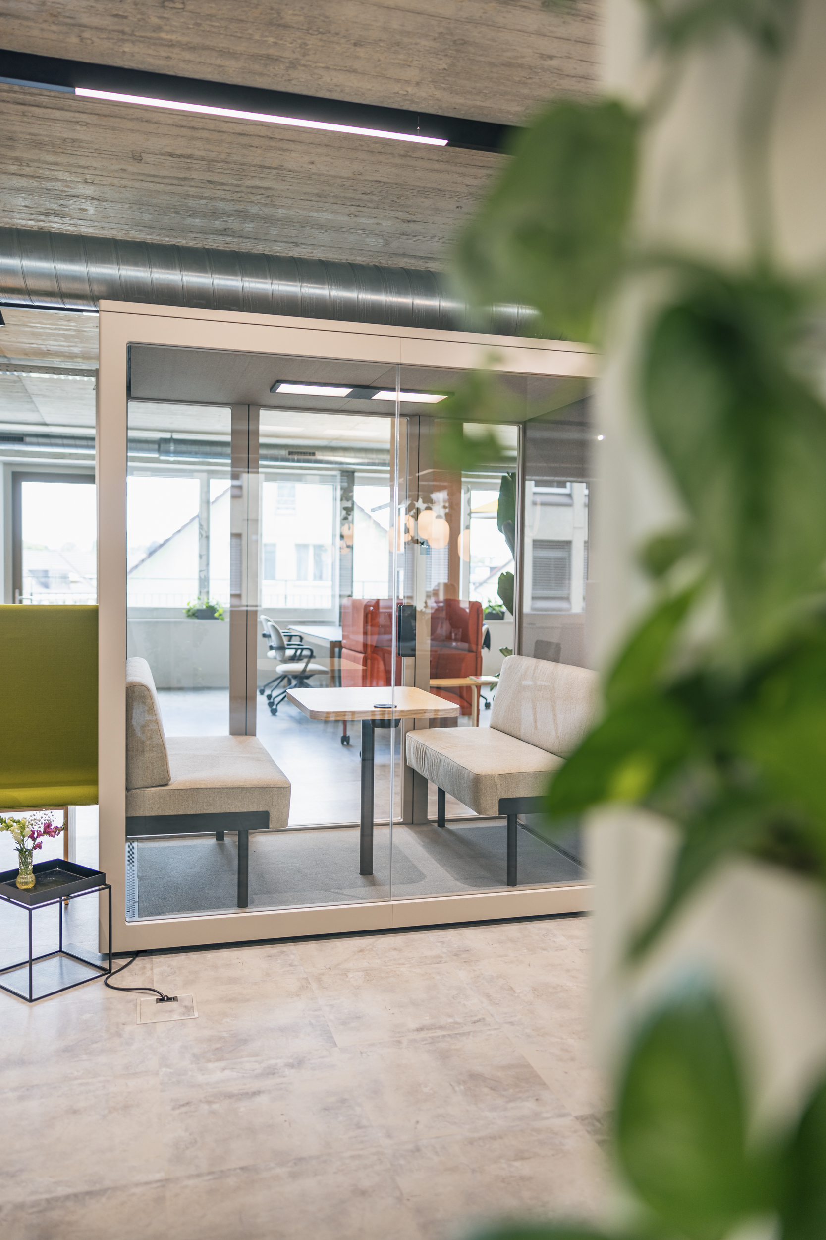 Besprechugngsbox mit zwei Sofas und einem Tisch.