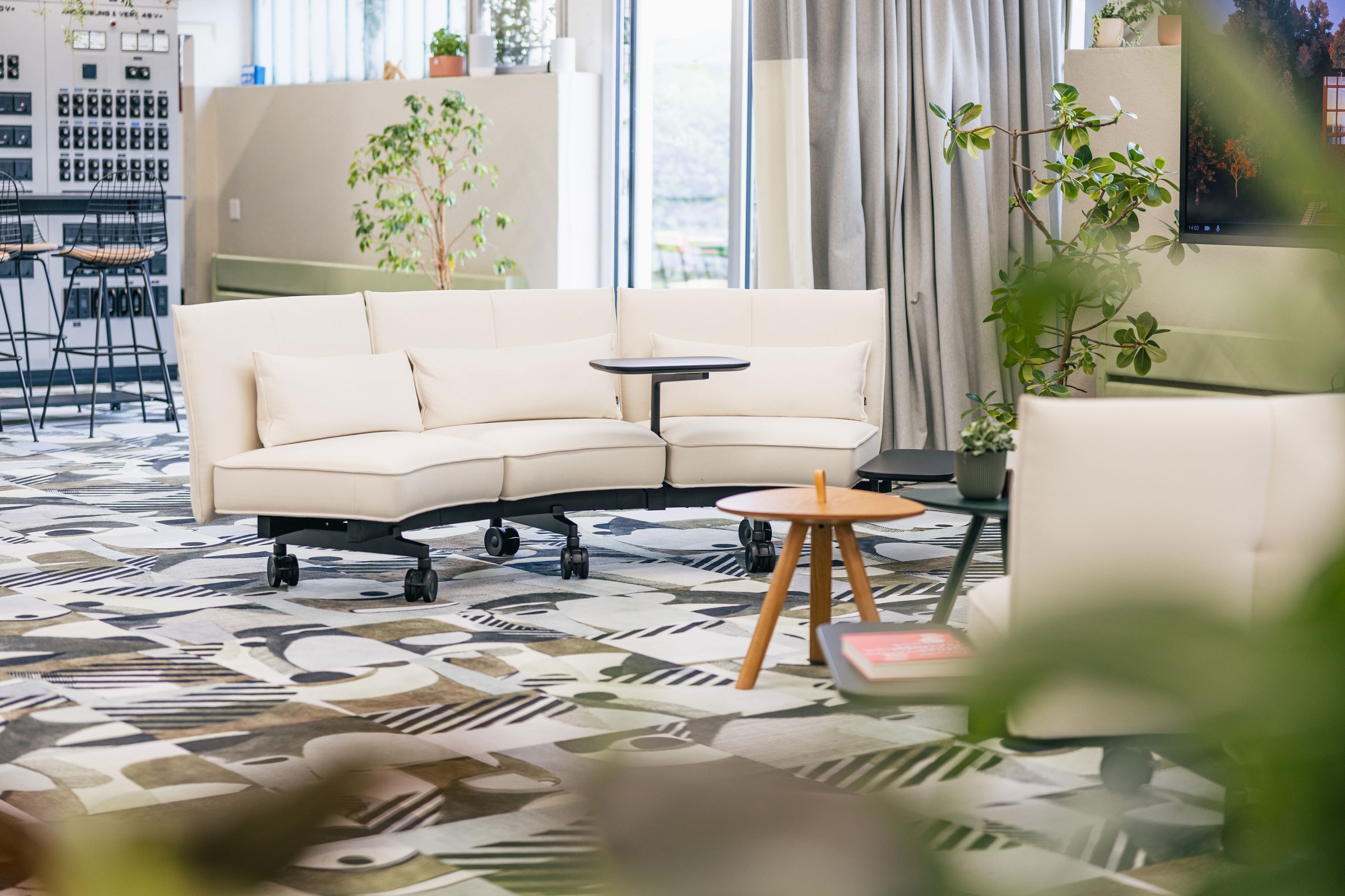 Großer, offener Arbeitsbereich mit Lounge, Arbeitstischen und Pflanzen.